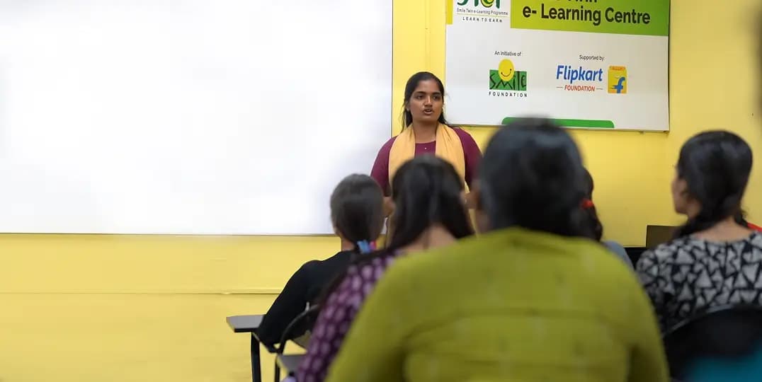 Facilitator addresses seated group at community e-learning center