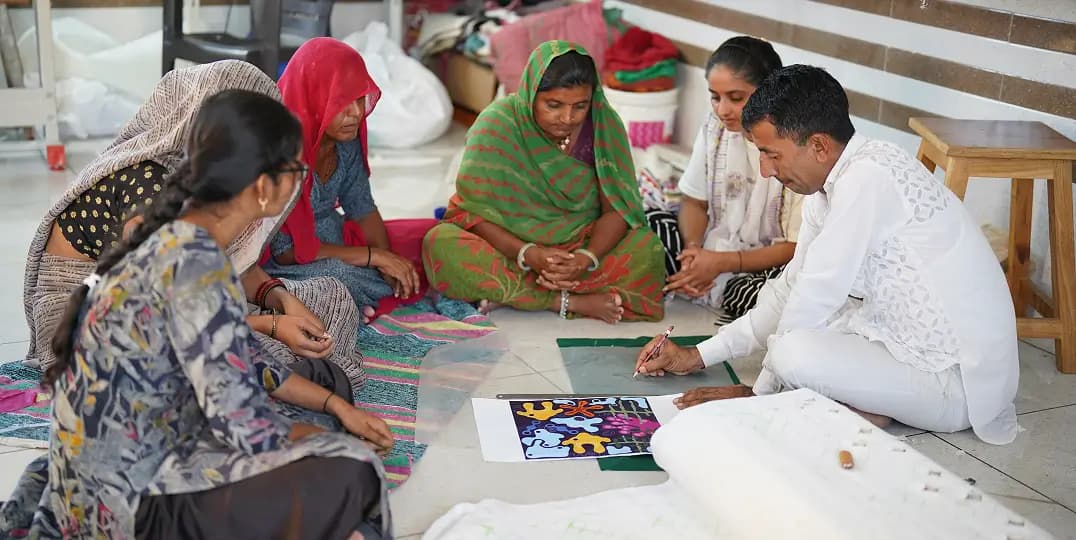 Women and a man collaborate on handmade textile craftwork